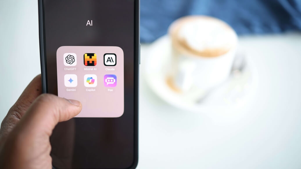 Smartphone affichant des applications, tasse de café flou à l'arrière-plan.