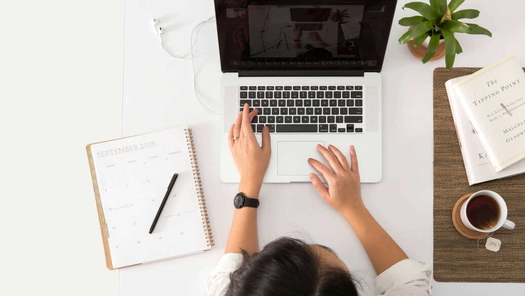 Personne travaillant sur un ordinateur portable à un bureau organisé.