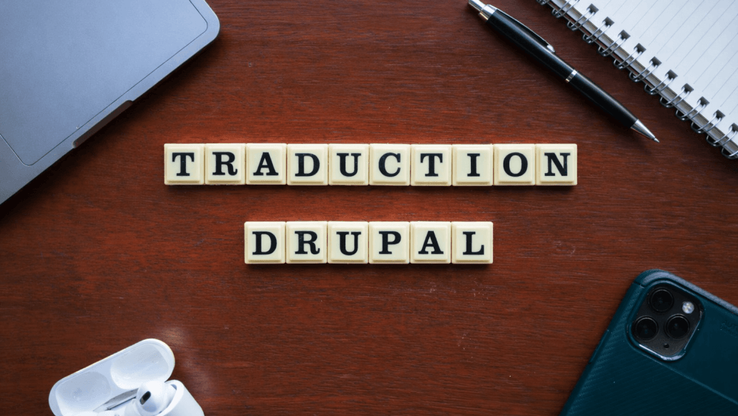 Lettres en bois formant "TRADUCTION DRUPAL" sur un bureau en bois, avec stylo et carnet. Image générée par l'IA