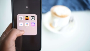 Smartphone affichant des applications, tasse de café flou à l'arrière-plan.