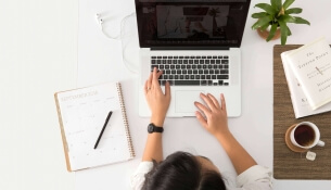 Personne travaillant sur un ordinateur portable à un bureau organisé.